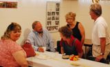 Barb takes time from running the party to share a laugh with friends.